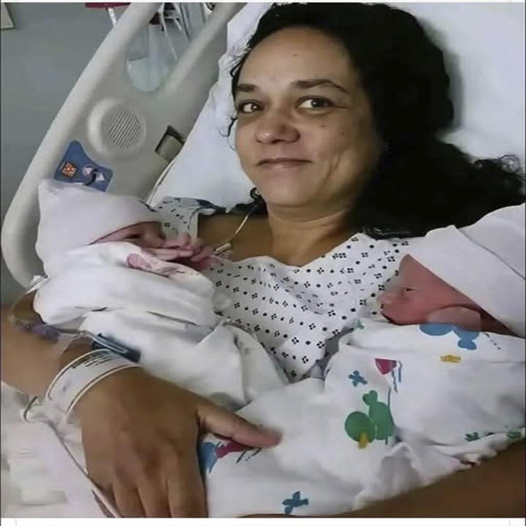 Mujer sosteniendo a sus gemelos recién nacidos